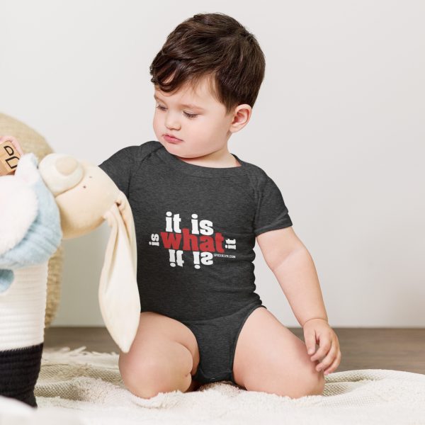 A baby in a onesie playing with a stuffed animal