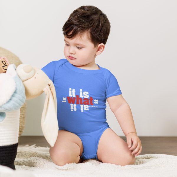 A baby in blue shirt playing with stuffed animal.