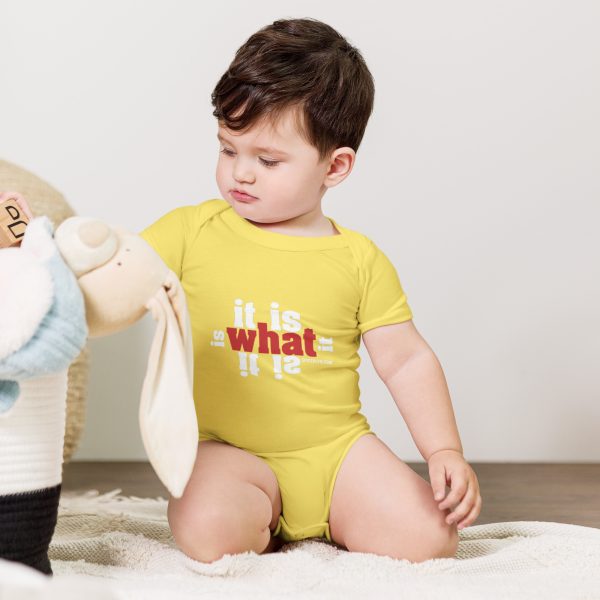 A baby in yellow shirt playing with stuffed animal.