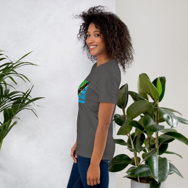 A woman standing next to some plants wearing jeans