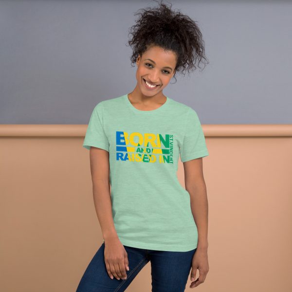 A woman standing in front of a wall wearing jeans and a t-shirt.